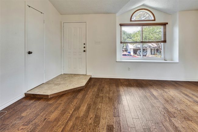 Foyer featuring wood finished floors, a textured ceiling, and vaulted ceiling | Image 20