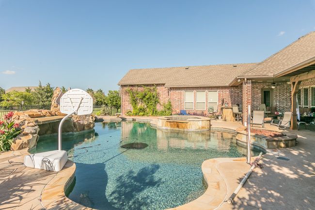 View of swimming pool with a patio, a pool with connected hot tub, and a ceiling fan | Image 35
