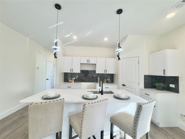 Kitchen with visible vents, backsplash, light wood-style floors, and a sink | Image 8