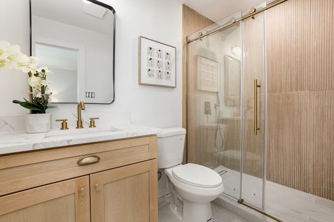 Bathroom with a shower stall, toilet, vanity, and tile patterned floors | Image 7