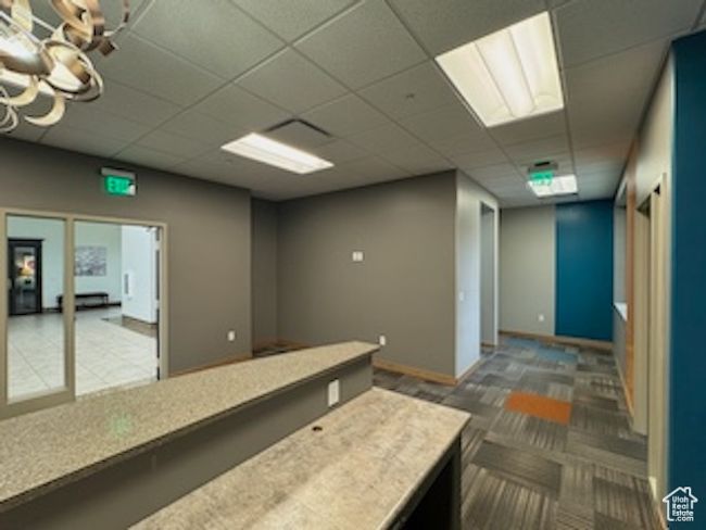 Interior space with a paneled ceiling, light countertops, and carpet flooring | Image 5