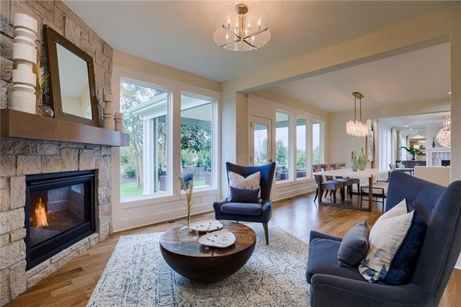 Living room featuring a notable chandelier, hardwood / wood-style floors, and a fireplace | Image 13