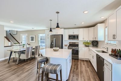 (Photo of decorated model, actual home's finishes may vary slightly) This thoughtfully-designed kitchen layout features quartz countertops, LVP wood flooring, stainless appliances and more! | Image 2