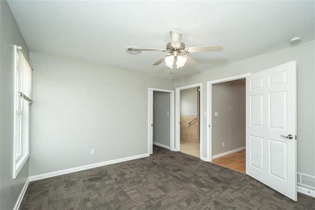 Unfurnished bedroom with visible vents, a ceiling fan, ensuite bath, carpet flooring, and baseboards | Image 21