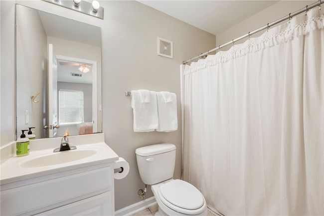 Bathroom featuring visible vents, toilet, and vanity | Image 13