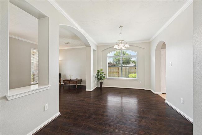 Entertain in style....candlelight and wine dinners for 2 to 10 can be yours in this dining room featuring beautiful engineered wood floors, crown molding and blinds on the window. | Image 12
