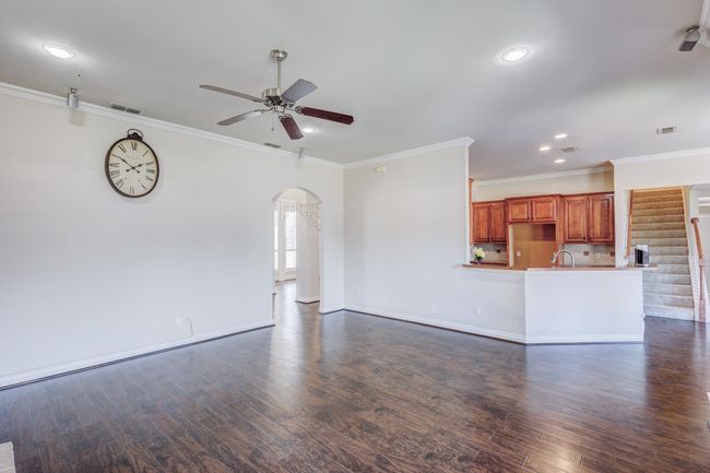 Unfurnished living room featuring ceiling fan, dark wood-type flooring, sink, and ornamental molding | Image 19