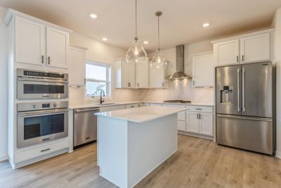 Photo is of the actual home. Welcome to the Vanderbilt! This gourmet kitchen features a spacious center island, quartz countertops, LVP floors, stainless appliances and more. | Image 2