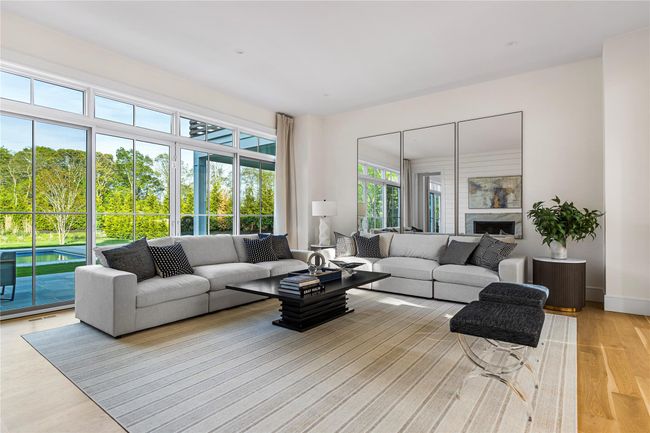 Living room featuring light wood-style flooring, a fireplace, and baseboards | Image 14
