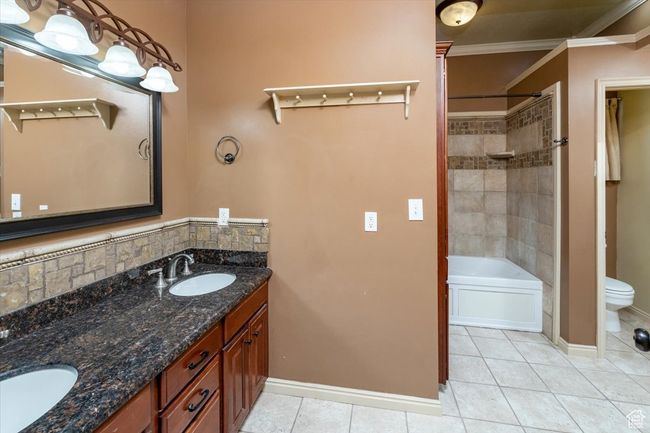 Full bathroom with vanity, tile patterned flooring, ornamental molding, toilet, and tiled shower / bath | Image 37