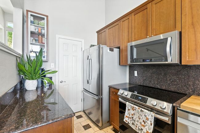 Kitchen featuring stainless steel appliances, brown cabinets, and backsplash | Image 13