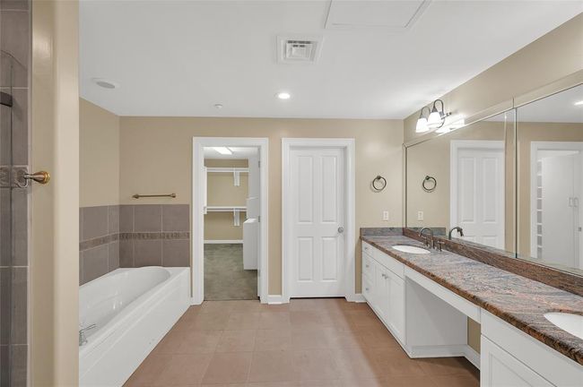 Spa-like Bathroom has extended vanity with dual sinks and granite tops. Walk-in shower with glass enclosure and separate jetted soaking tub. Facing closed door is private toilet room. | Image 8