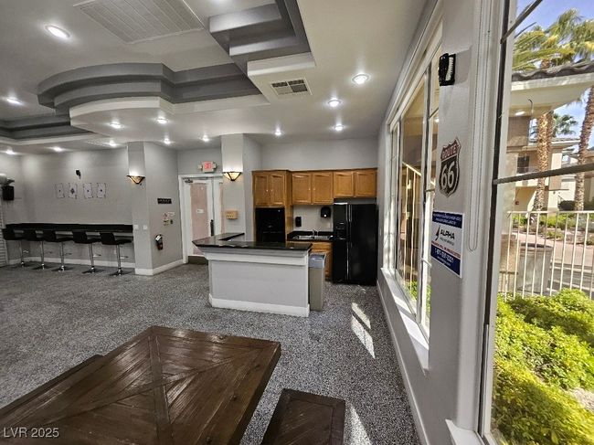 Kitchen featuring black refrigerator with ice dispenser, baseboards, dark countertops, and visible vents | Image 9