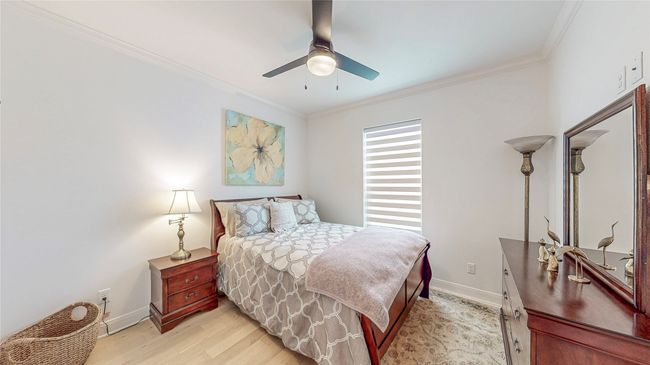 Bedroom with light wood-style floors, ornamental molding, and ceiling fan | Image 27