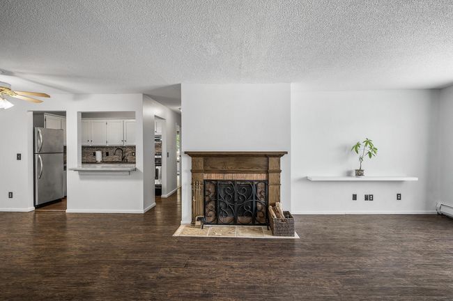 Rich wood-look flooring flows seamlessly through the living room, dining area, and kitchen, adding warmth throughout. | Image 8