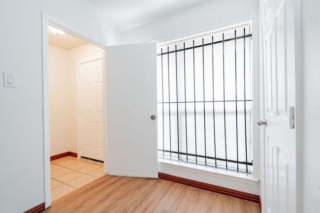 Empty room featuring a textured ceiling, light wood finished floors, and baseboards | Image 15