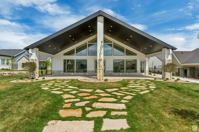 Back of house featuring board and batten siding, a patio area, a lawn, and fence | Image 39
