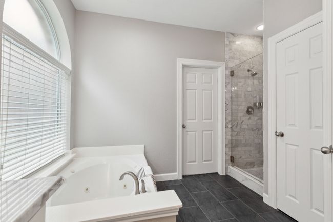 Full bath with a shower stall, a jetted tub, baseboards, and marble finish flooring | Image 18