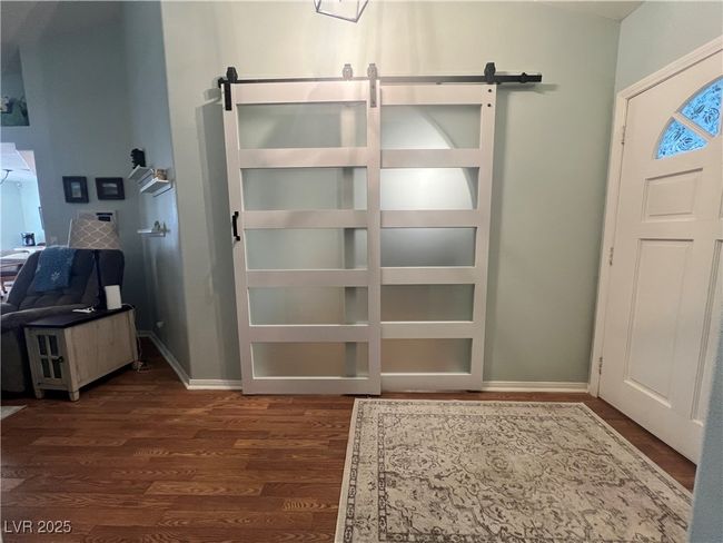 Entryway with a barn door and dark wood-style floors | Image 13