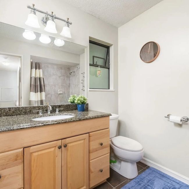 Bathroom featuring vanity, a shower with shower curtain, tile patterned flooring, a textured ceiling, and toilet | Image 9