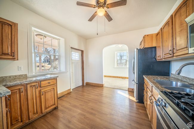 Kitchen with brown cabinetry, a healthy amount of sunlight, a sink, and appliances with stainless steel finishes | Image 5