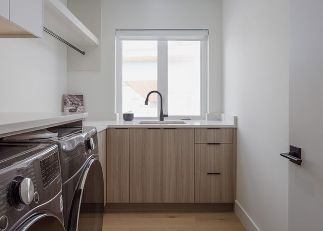 Laundry room with washing machine and clothes dryer, baseboards, light wood-style floors, cabinet space, and a sink | Image 29