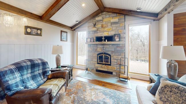 Living room w/wood-burning fireplace & stone surround + wall-length windows--great natural light! | Image 4