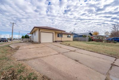 View of side of home with a lawn and a garage | Image 2