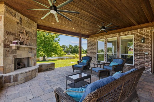 Outdoor living at its finest! Enjoy a fire on cool evenings in the gorgeous stone fireplace with gas logs. On warmer evenings ceiling fans will keep the temps down. And always, enjoy the views of the beauty of your property, including the pond. (The property line goes through the middle of the pond.) | Image 29