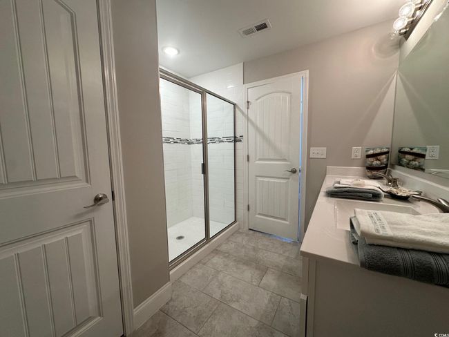 Full bath with visible vents, a stall shower, a sink, and toilet | Image 13