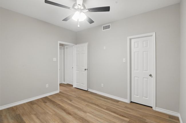 Unfurnished bedroom with light wood-style flooring, visible vents, baseboards, and ceiling fan | Image 20
