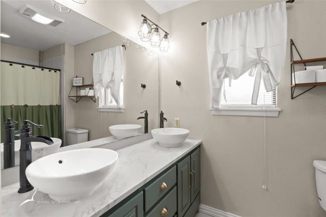 Bathroom featuring a sink, toilet, and a wealth of natural light | Image 17
