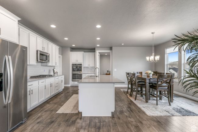 Kitchen featuring decorative backsplash, stainless steel appliances, recessed lighting, and a center island with sink | Image 4