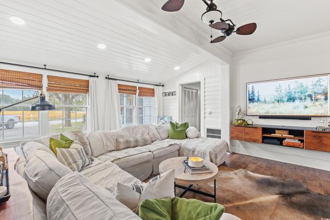 Living room featuring a ceiling fan, wood finished floors, vaulted ceiling, healthy amount of natural light, and recessed lighting | Image 5