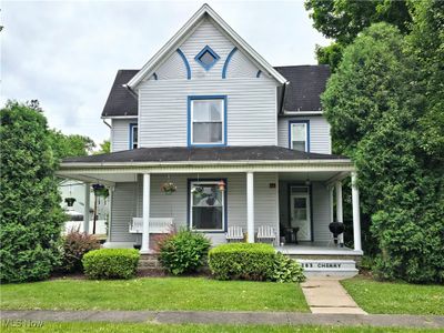 View of front facade featuring covered porch and a front lawn | Image 1