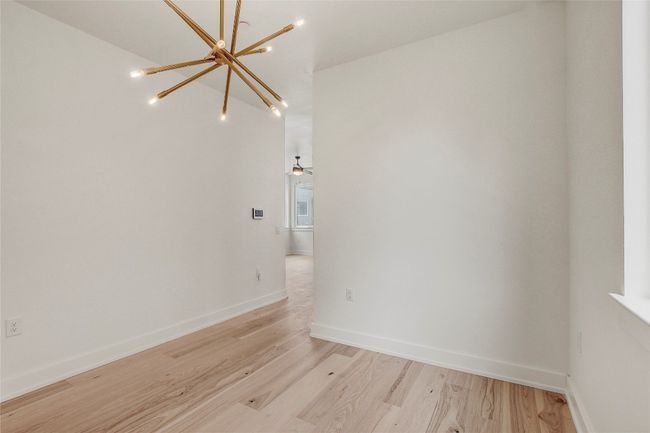 Empty room featuring a chandelier, light wood-type flooring, and baseboards | Image 14