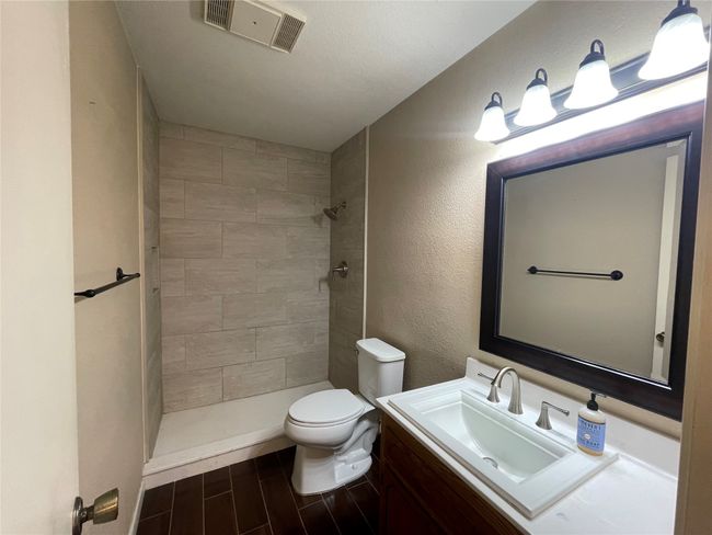 Full bath featuring toilet, tiled shower, vanity, and wood finished floors | Image 21