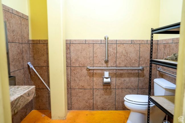 Bathroom featuring toilet, a wainscoted wall, and tile walls | Image 29