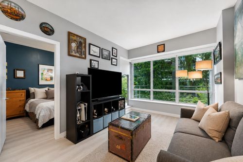Bright living space featuring large picture windows, light wood-finish flooring, and a recessed ceiling | Card Image