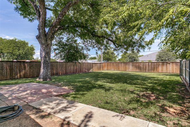 Fenced backyard with a patio | Image 24