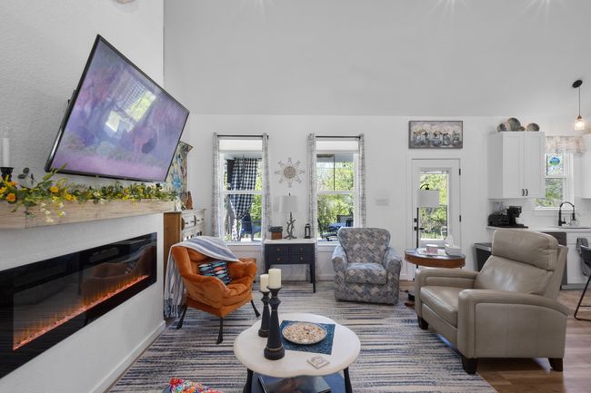 Living area with baseboards, wood finished floors, and a glass covered fireplace | Image 18