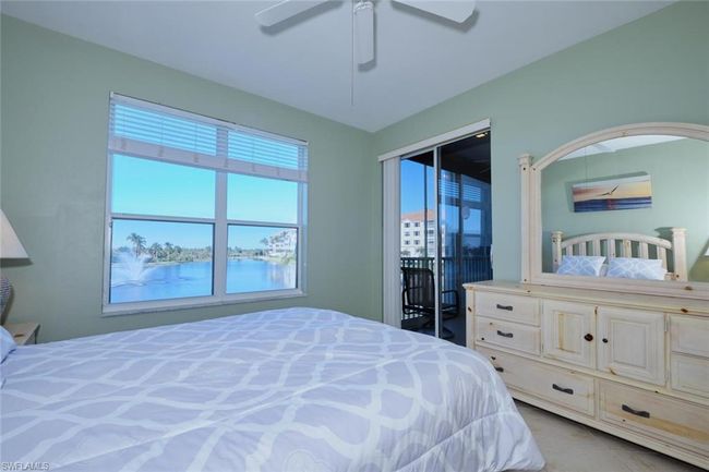 Bedroom with ceiling fan and a water view | Image 35