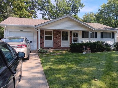 Ranch-style home with a front lawn and a garage | Image 1