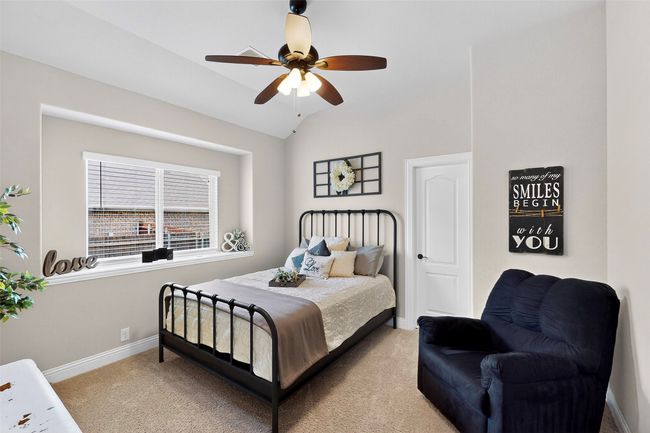 Bedroom with light colored carpet, baseboards, ceiling fan, and vaulted ceiling | Image 21