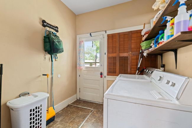 Washroom with washing machine and clothes dryer, baseboards, and stone finish flooring | Image 32