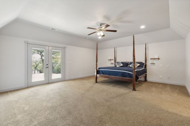 Carpeted bedroom featuring access to outside, french doors, vaulted ceiling, and ceiling fan | Image 20