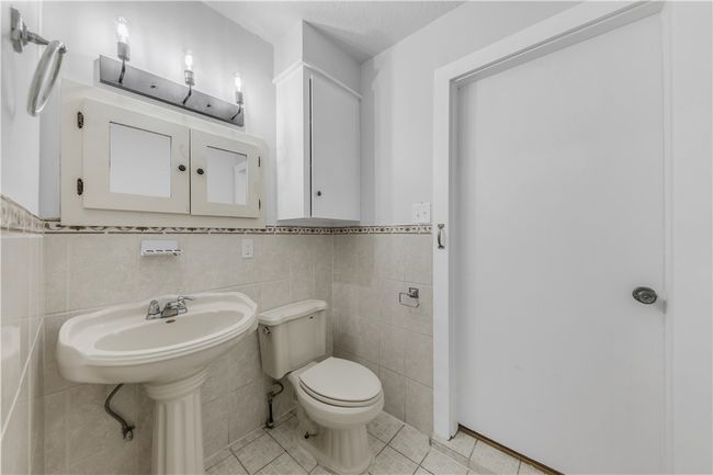 Bathroom with tile patterned floors, toilet, and tile walls | Image 15