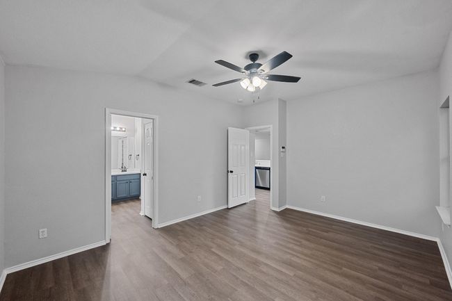 primary bedroom with new finished floors, paint, connected bathroom, and a ceiling fan | Image 13