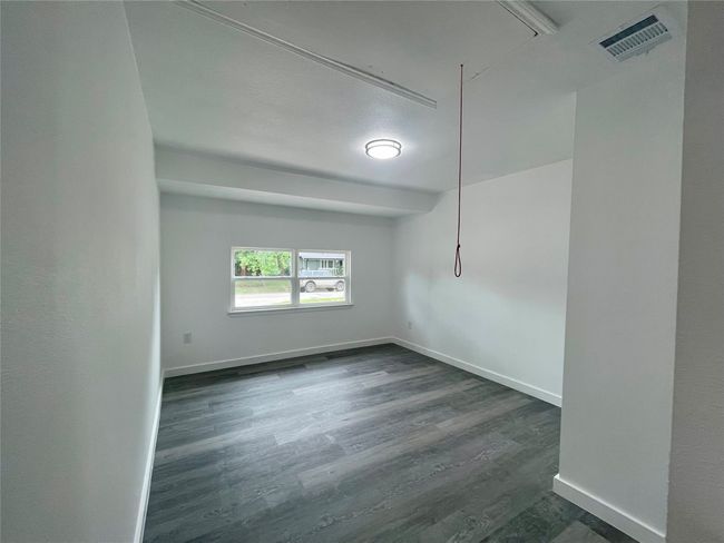 Unfurnished room with dark wood-style floors and baseboards | Image 13