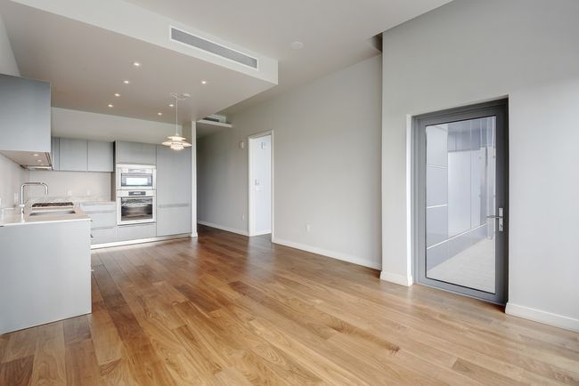 Unfurnished living room featuring a sink, light wood-style flooring, and baseboards | Image 5